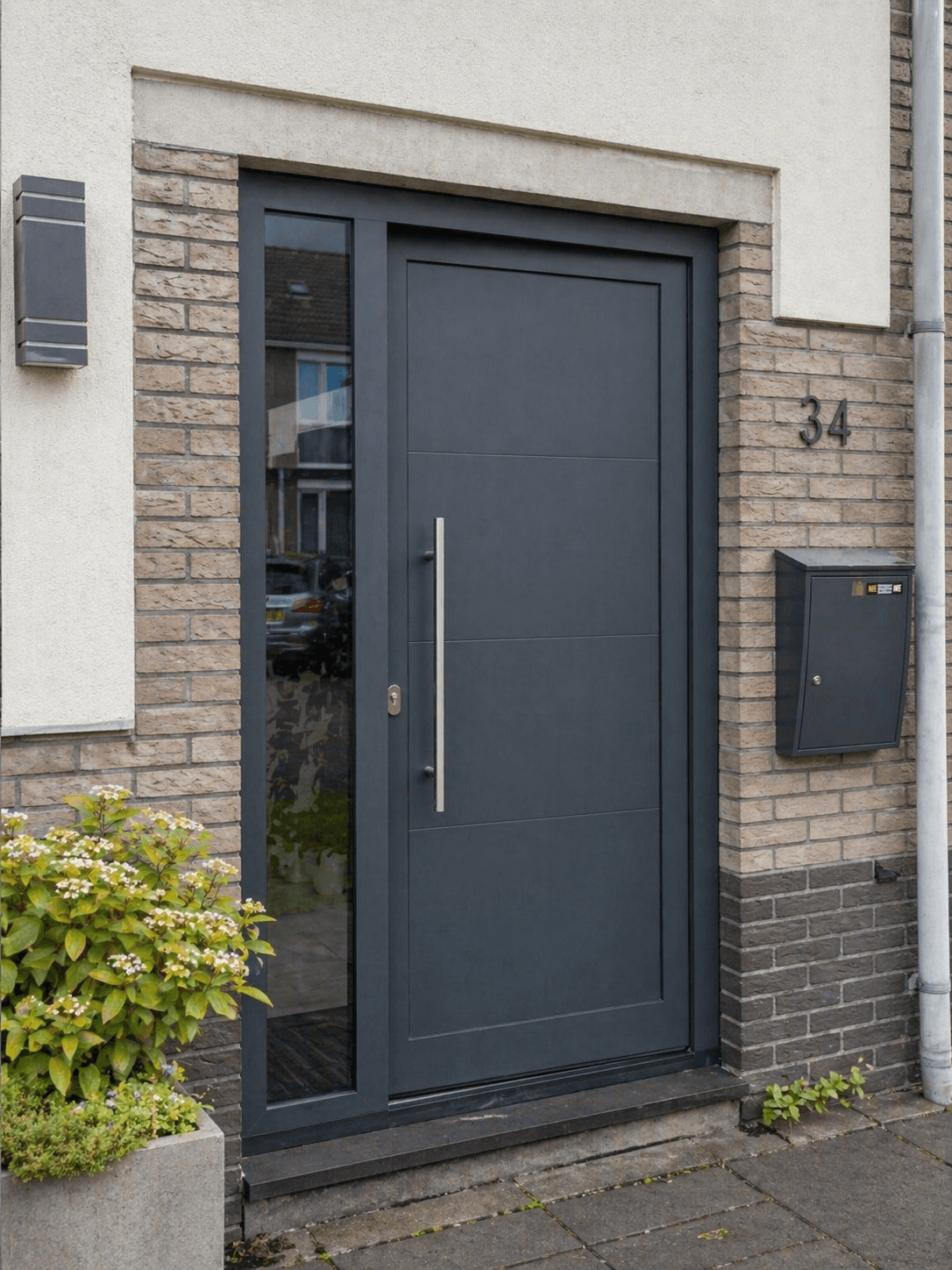 Moderne antraciet aluminium voordeur met zijlicht en lange greep in bakstenen gevel