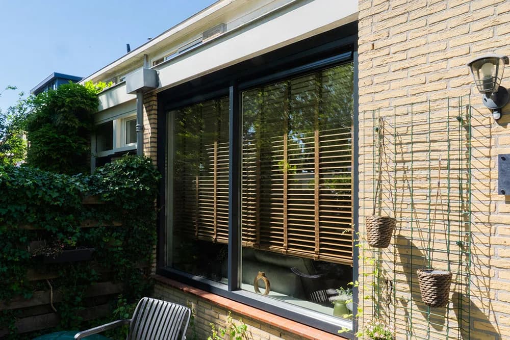 Aluminium schuifpui in antraciet met uitzicht op achtertuin — moderne villa Wassenaar
