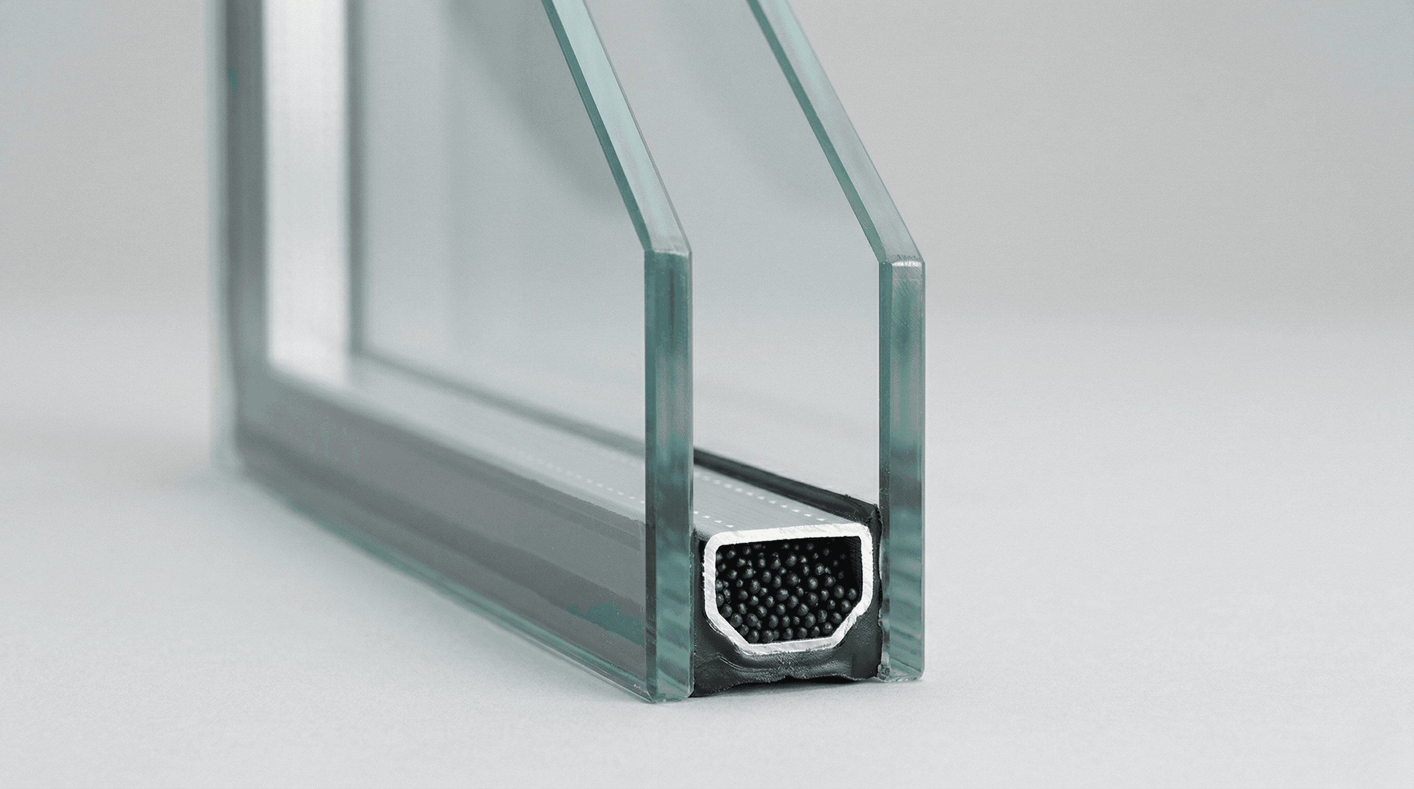 Doorsnede van dubbel glas met de aluminium afstandhouder waarin de productiecode staat