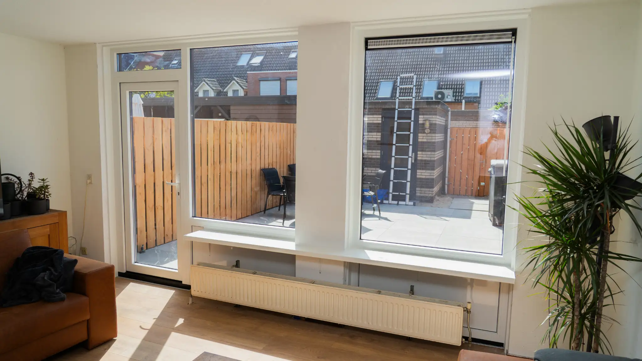 Woonkamer met nieuwe witte kozijnen en een tuindeur naar de tuin